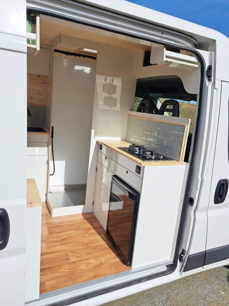 Cocina de furgoneta camper con acabados de madera. Camper Tarraco experto en neveras portatiles.